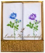 Two white handkerchiefs with colorful floral embroidery feature a blue rose and a purple rose with green leaves inside a decorative golden box labeled 2 Ladies Handkerchiefs