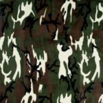 A patterned fabric featuring a combination of dark green light green and white shapes resembling flames or abstract forms against a brown background creating a camouflage appearance.