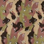 A camouflage fabric features an abstract pattern with shades of green brown and black irregular shapes and spots blending together creating a design suitable for military or outdoor clothing