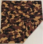 A folded piece of fabric featuring a camouflage pattern with shades of brown tan and black lies flat against a plain background displaying a mix of organic shapes and colors.