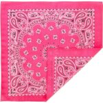 A pink bandana with intricate white and black paisley patterns is partially folded revealing a corner and showcasing its vibrant color and detailed design against a plain background.