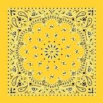 A yellow bandana features a symmetrical paisley pattern with intricate black designs radiating from the center creating a vibrant decorative effect against a solid background.
