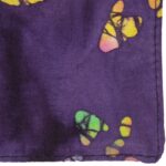 A purple fabric features colorful butterfly patterns in yellow pink green and orange showcasing a textile design with intricate details and vibrant colors likely used for clothing or home decor.