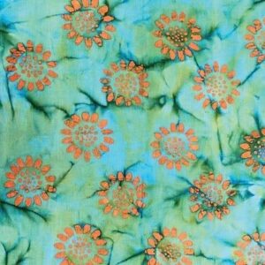 A fabric features a pattern of orange flowers with green accents against a blue and green tie-dye background creating a vibrant floral design spread evenly across the material.