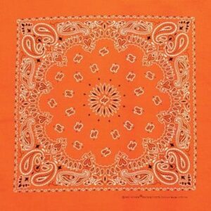 An orange bandana features intricate white paisley designs and floral motifs arranged symmetrically over the entire fabric creating a vibrant decorative pattern suitable for various uses.