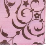 A pink fabric features intricate brown floral and star patterns  creating a decorative design that showcases the softness and texture of the material against a plain background.