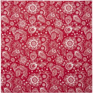 A red patterned fabric features intricate white floral and paisley designs arranged evenly throughout the surface creating a vibrant and decorative visual effect suitable for various textile applications.