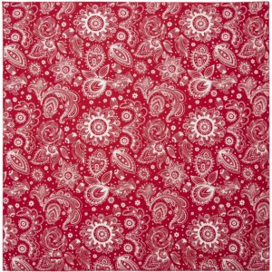 A red fabric with intricate white floral and paisley patterns covers the surface showing a mix of large and small designs amidst swirls and leaves creating a vibrant textile appearance.