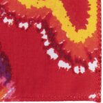 A vibrant red fabric features swirling patterns in yellow and white suggesting movement or flow with irregular edges and a stitched border indicating it is likely a piece of textile art or design.