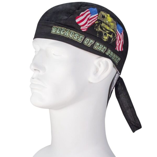 A black bandana adorned with American flags and a skull design rests on a white mannequin head showcasing the text "BECAUSE OF THE BRAVE" prominently displayed across the front.