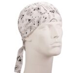 A white bandana with black paisley patterns is tied around a mannequin’s head  resting snugly in place  showcasing its design in a neutral setting against a plain background.