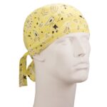 A yellow bandana with a paisley pattern is tied around a mannequin's head displaying a neutral expression and smooth features in a plain background setting.