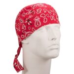 A red bandana with white patterns is tied around a mannequin's head showcasing a stylish look in a neutral setting emphasizing the bandana's vibrant color and design.