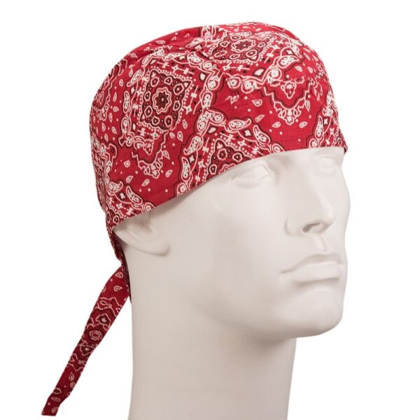 A red bandana is tied around the head of a white mannequin displaying a paisley pattern while the background is plain and lacks additional context or detail.
