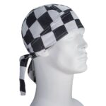 A black and white checkered bandana is tied around a mannequin's head the fabric covers the top and back with long tails hanging down the side in a neutral background