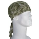 A green bandana is tied around a mannequin's head with a long trailing tail hanging down the side in a neutral setting highlighting the bandana’s camouflage pattern.