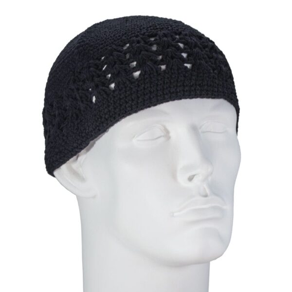 A black crocheted cap sits snugly on a plain white mannequin head facing slightly to the side in a neutral setting highlighting the cap’s intricate pattern and texture.