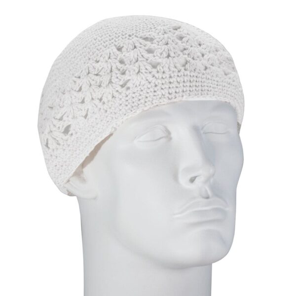 A white knitted cap sits on the head of a mannequin with a neutral expression gazing slightly upward against a plain background  showcasing the cap's intricate pattern and texture.