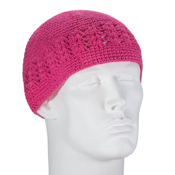 A pink crocheted beanie sits on a white mannequin head showcasing its textured pattern in a neutral setting emphasizing the design and color of the hat.