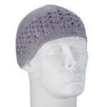 A gray crochet cap is displayed on a white mannequin head indicating a snug fit and decorative pattern showcasing an open weave design in a plain background.